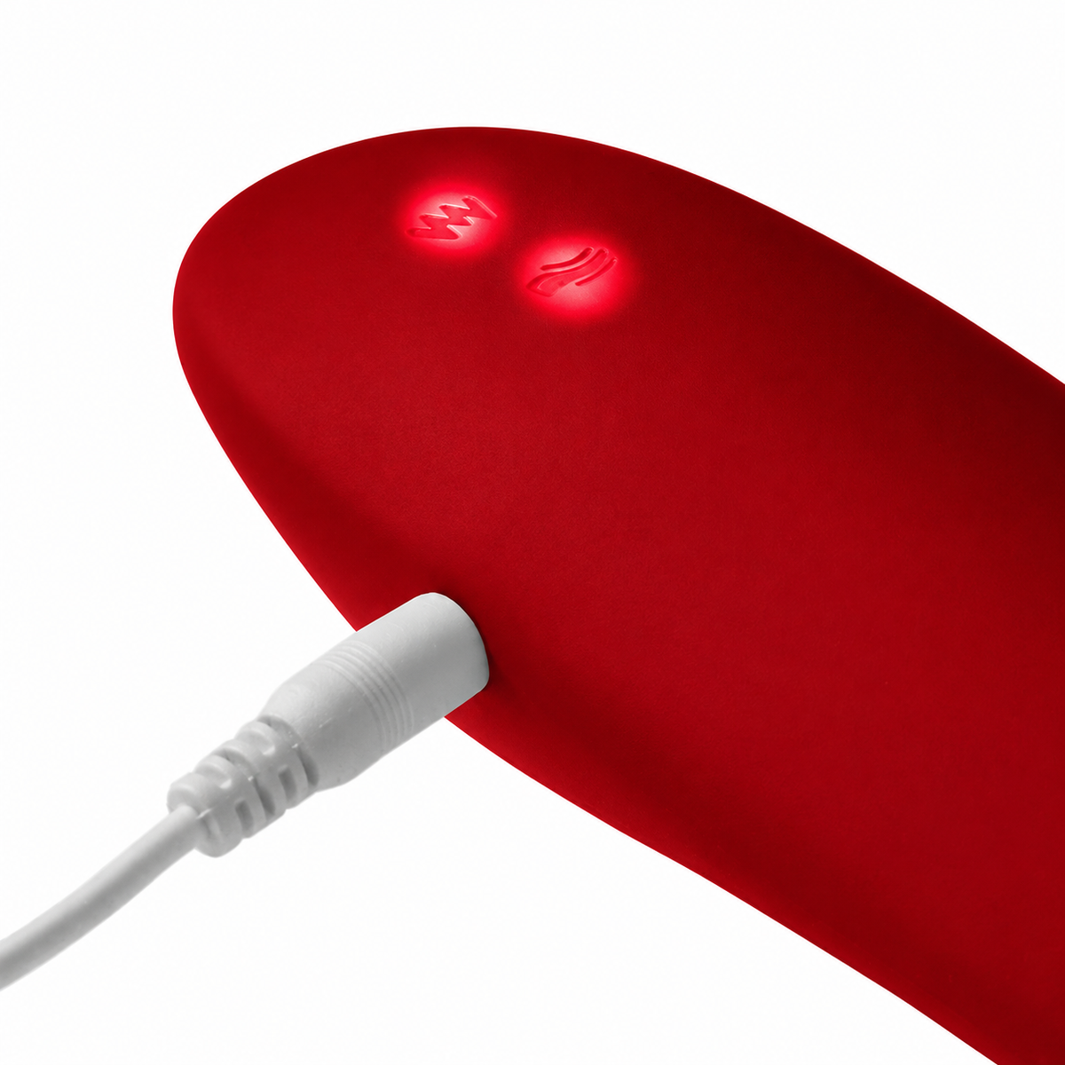 A close-up of a red curved electronic device with two illuminated control buttons and a white cable plugged into one side, shown on a white background.